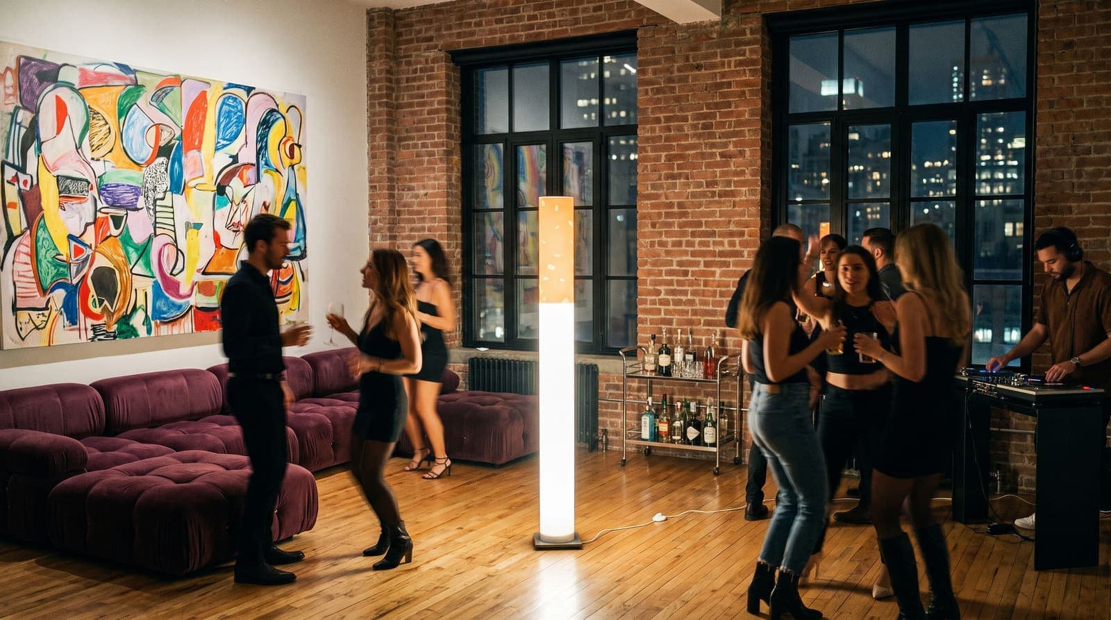 A dozen friends dancing in a brick loft at one in the morning with a DJ in the corner, the floor lamp glowing in the middle of the room