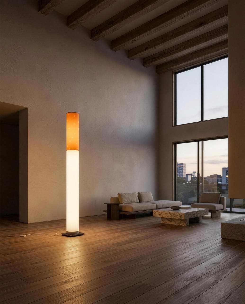 The tall beamed room at dusk, the floor lamp the brightest thing in it